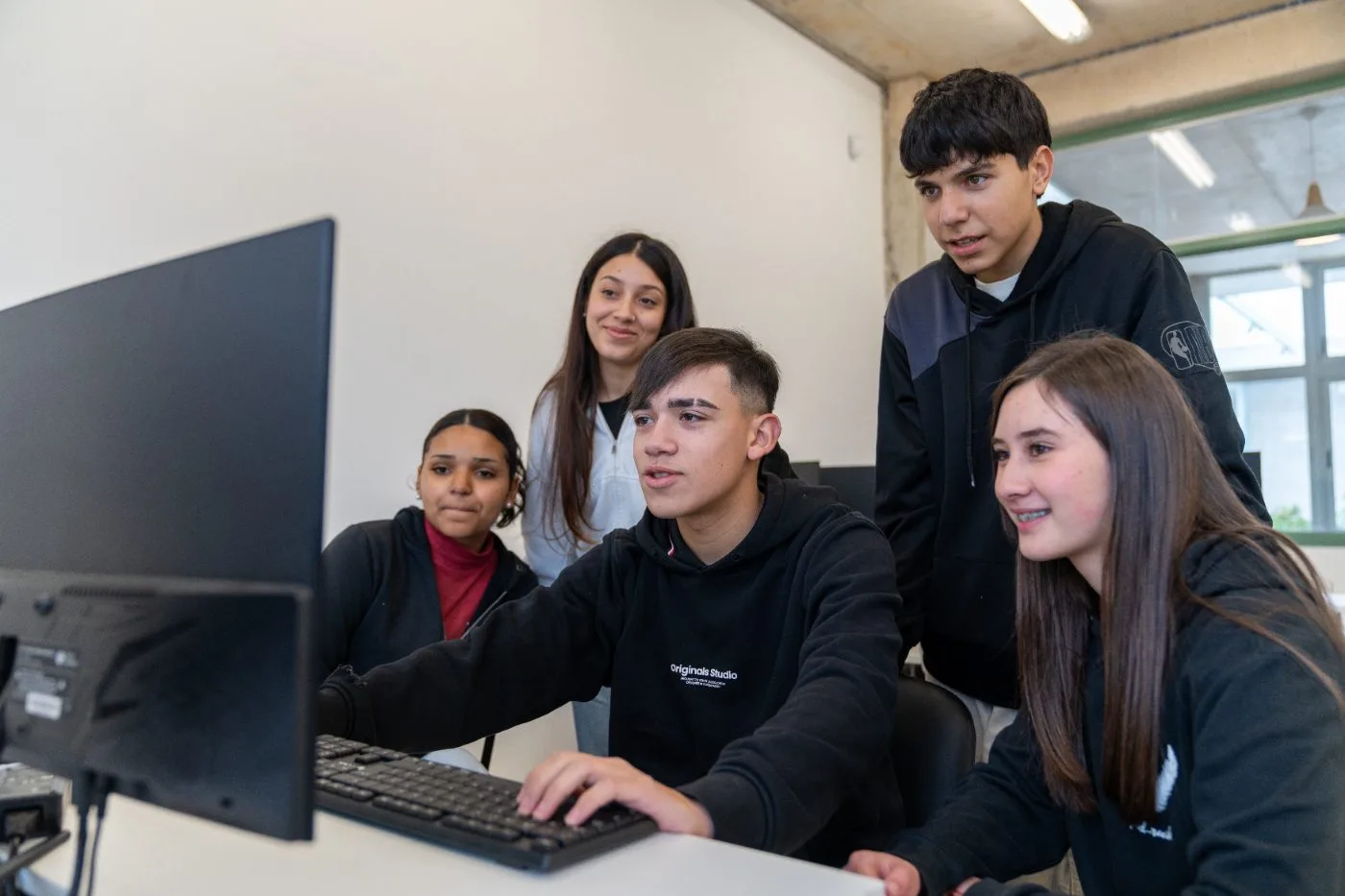 Estudiantes frente a una computadora en la UTU